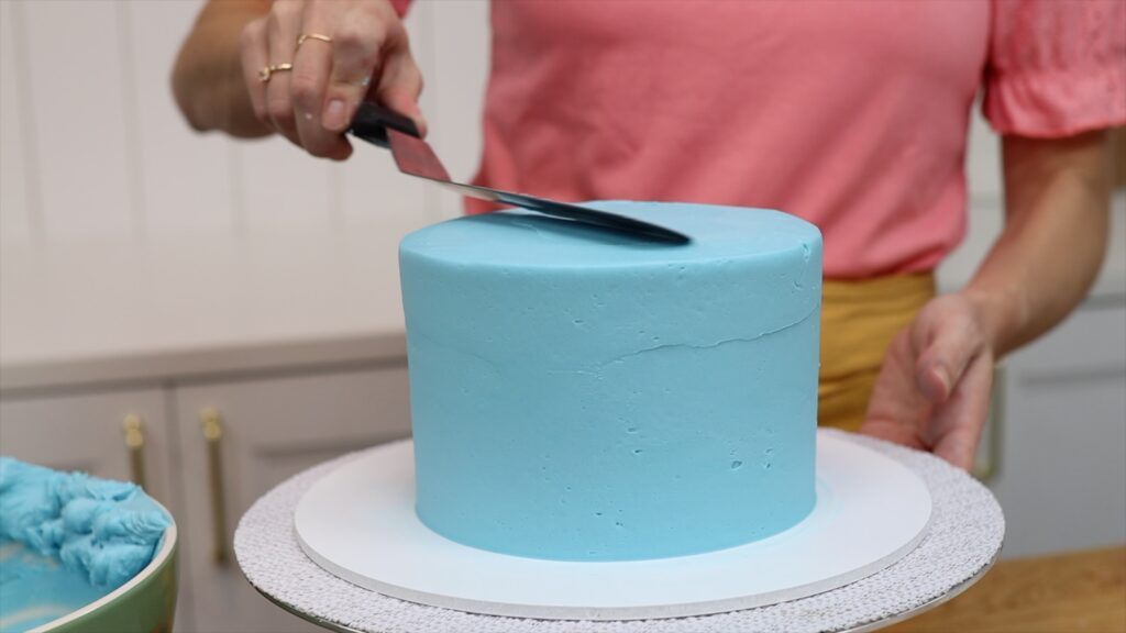 smoothing the frosting on a cake