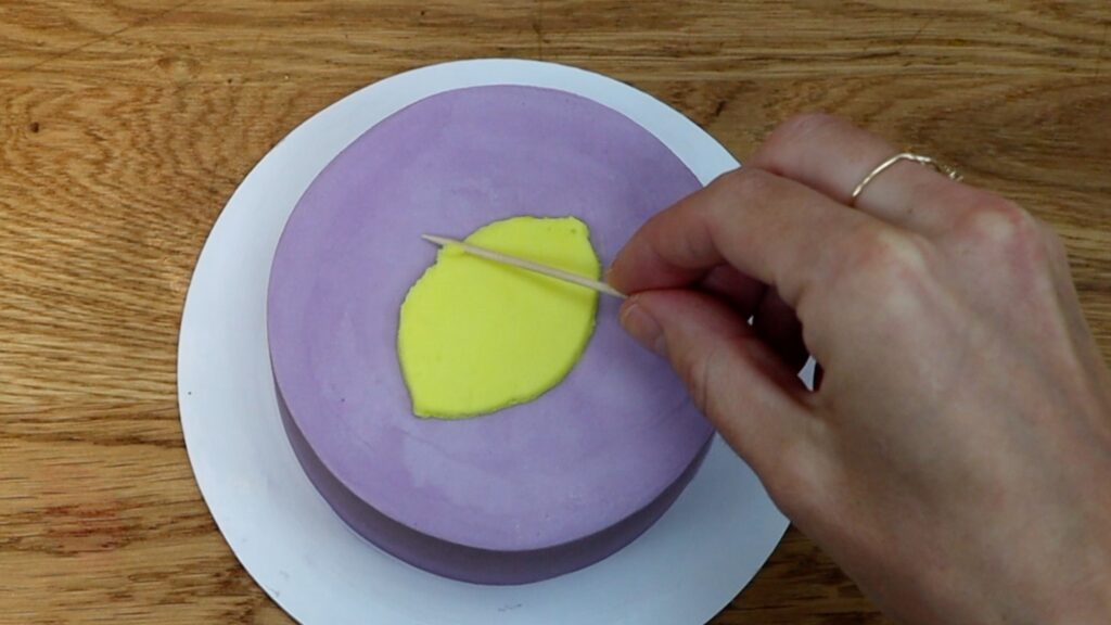 use a toothpick to tidy up stencil design on cake