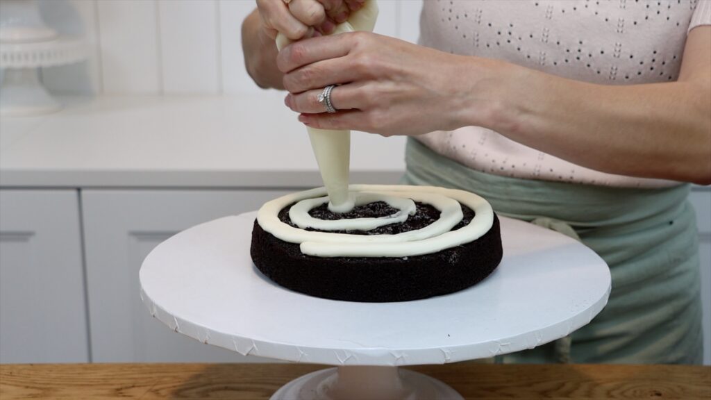 piping filling onto a semi naked cake