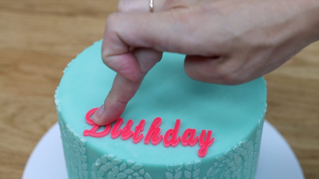 arrange your sweet stamp letters before pressing them into the frosted cake