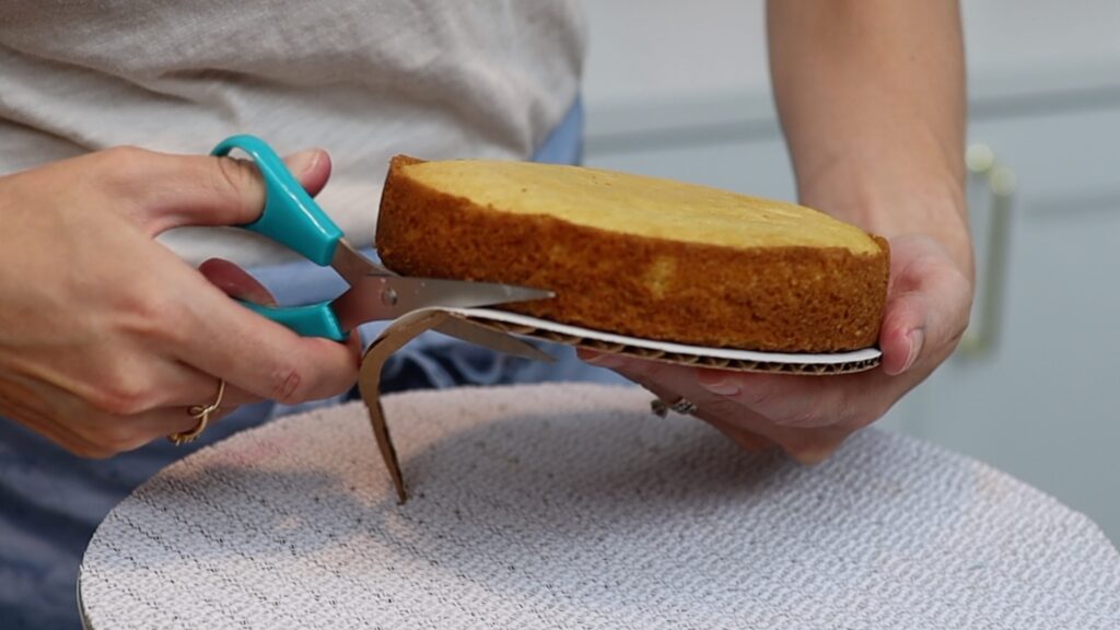 trim cardboard cake board with scissors to be same size as cake