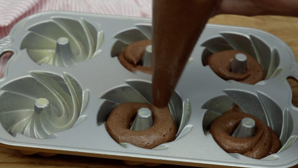 how to fill a mini bundt cake mold with batter using a piping bag