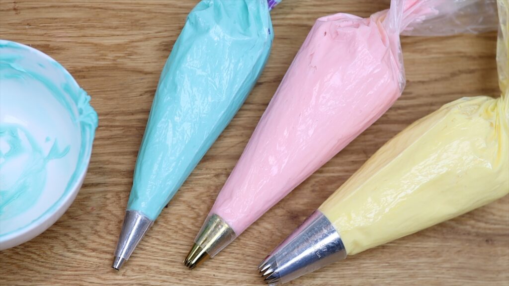 prepare piping bags of coloured buttercream for face lift frosting