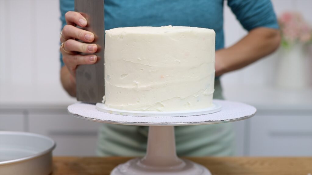 scrape frozen frosting with a hot metal cake comb