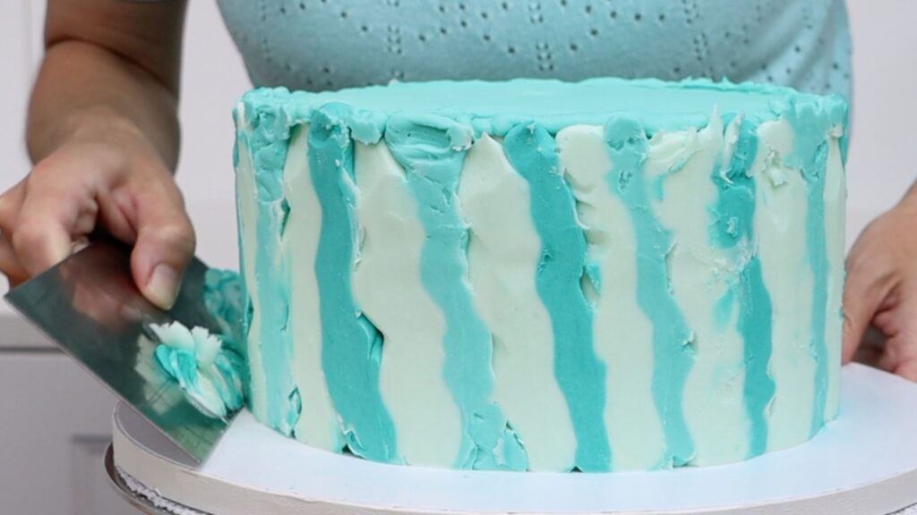 scrape the frozen piping off the cake using different directions