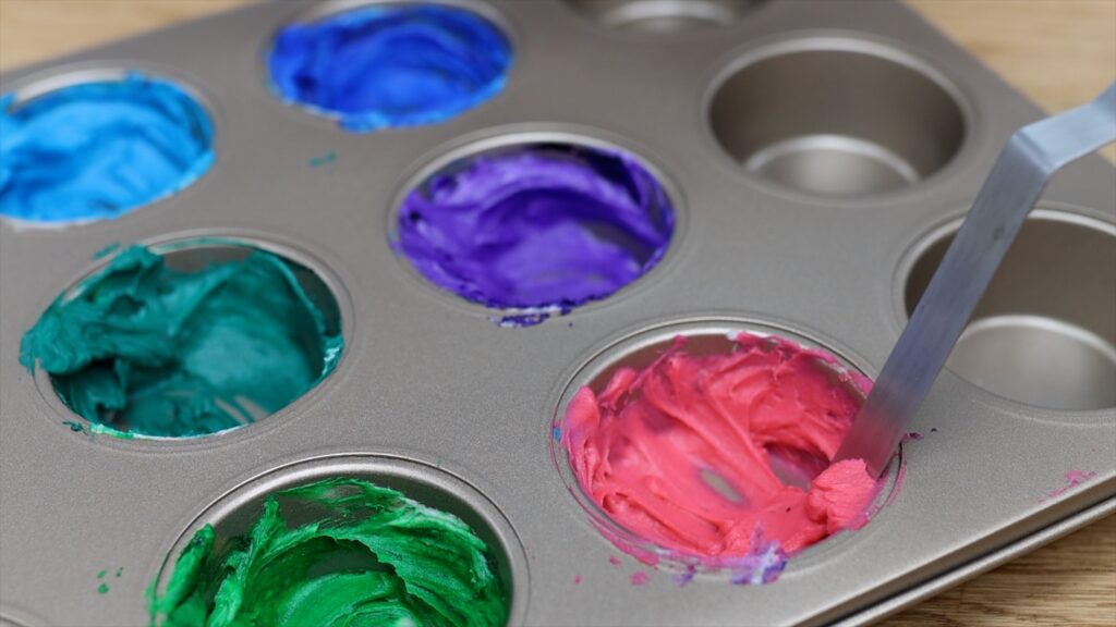 tinting buttercream in a cupcake pan