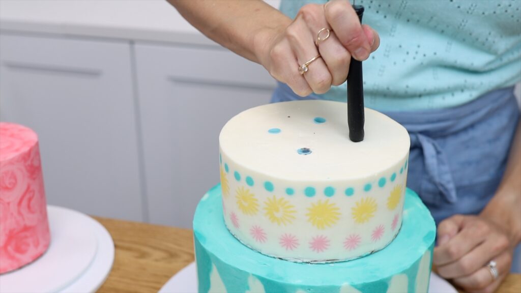 use the handle of your offset spatula to push straws or dowels into the cake