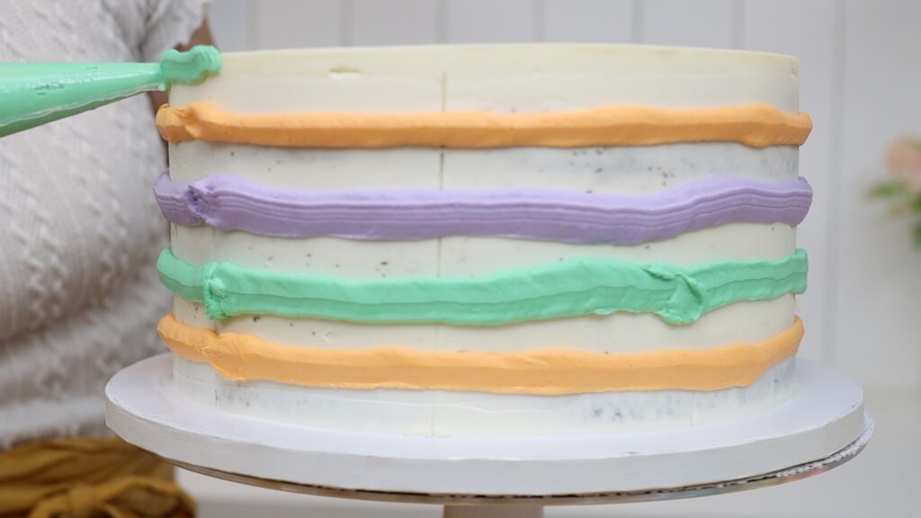 pipe frosting before using a striped cake comb for multicoloured stripes