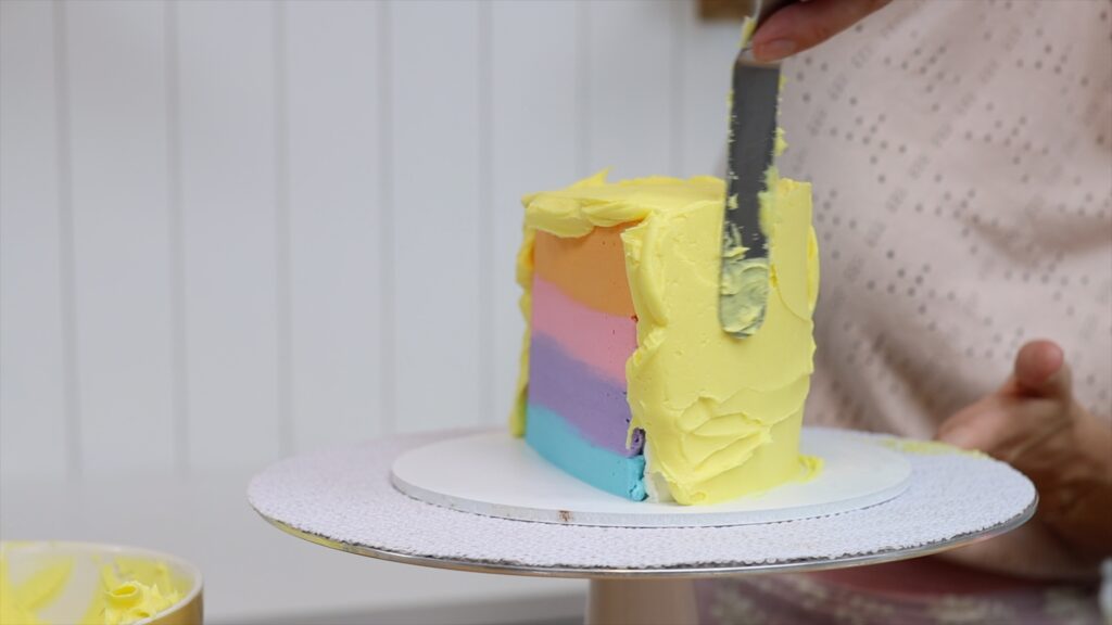 spreading frosting around the curved side of a half birthday cake