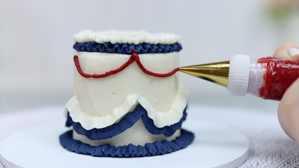 piping vintage buttercream patterns on cake using cookie cutter guidelines