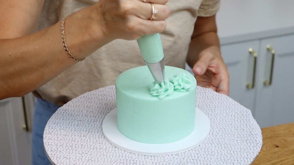 piping swirls onto cakes with a star tip