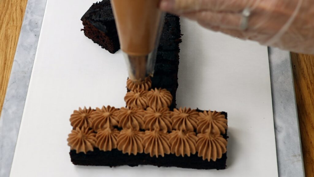 piping filling onto a number cake