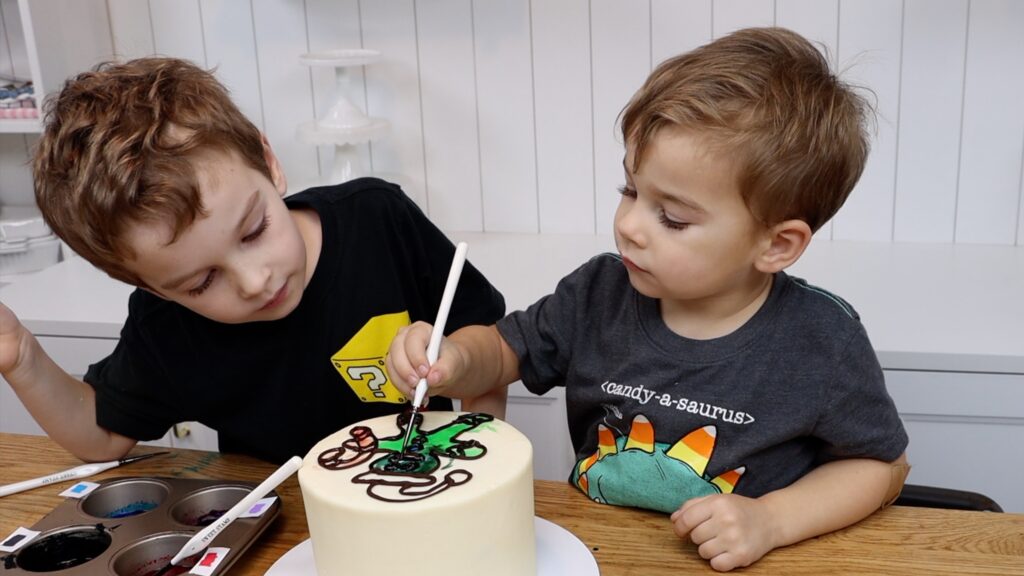 kids coloring on a cake