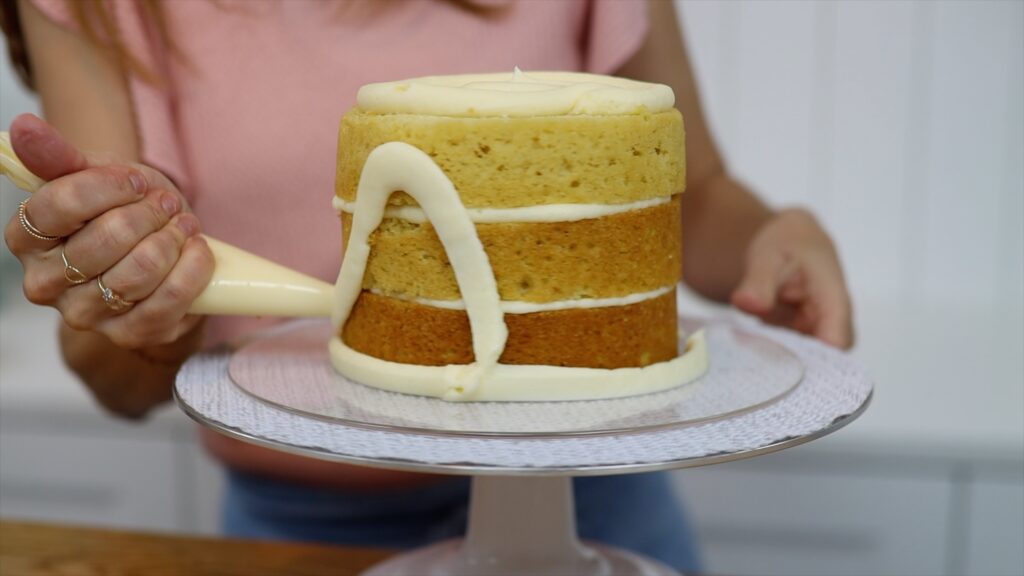 using piping bags as tools to decorate a cake and add filling and frosting