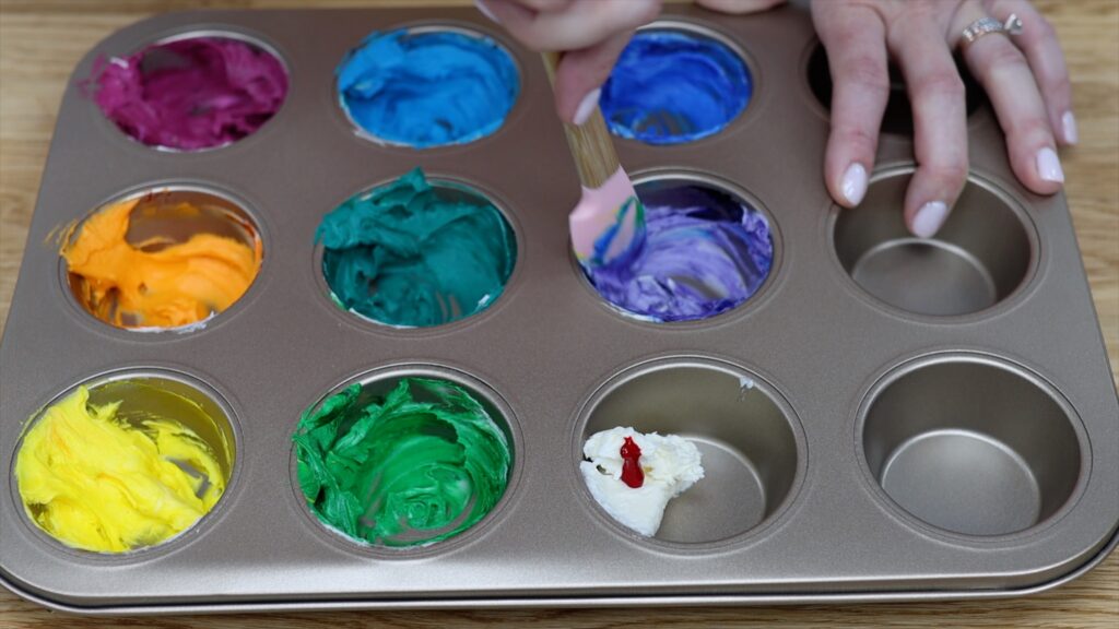 mix colours for a rainbow cake in a cupcake pan