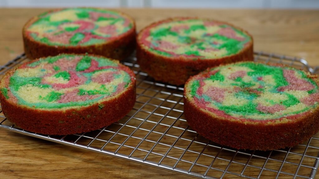 piping cake batter to make rainbow cakes