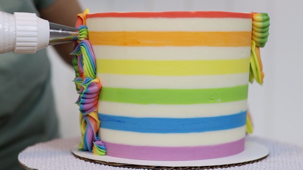 piping on a rainbow half stripe cake