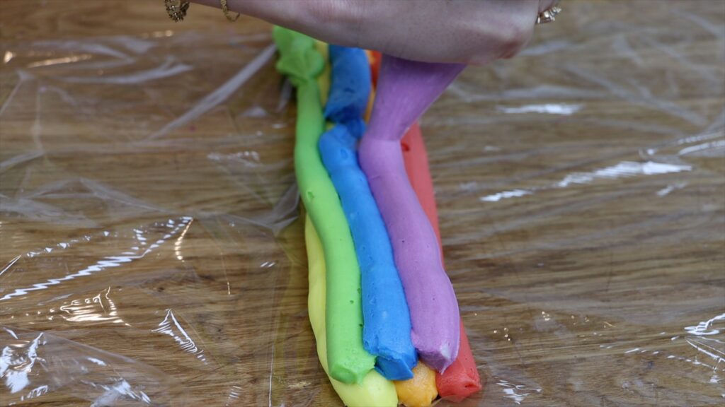 rainbow colours on saran wrap for piping onto a rainbow cake