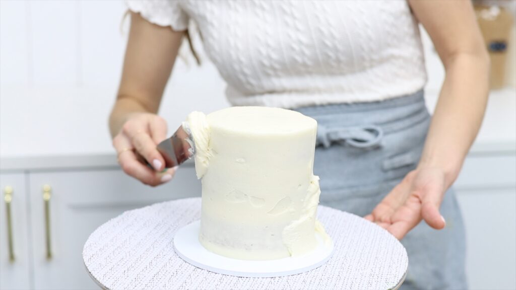 fix cake struggles with leaning cake by spreading more frosting to create straight sides and correct the lean