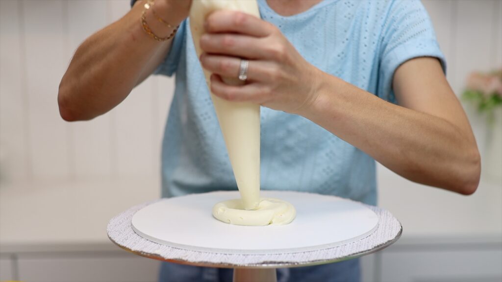 attach cakes to cake board with a dot or ring of buttercream