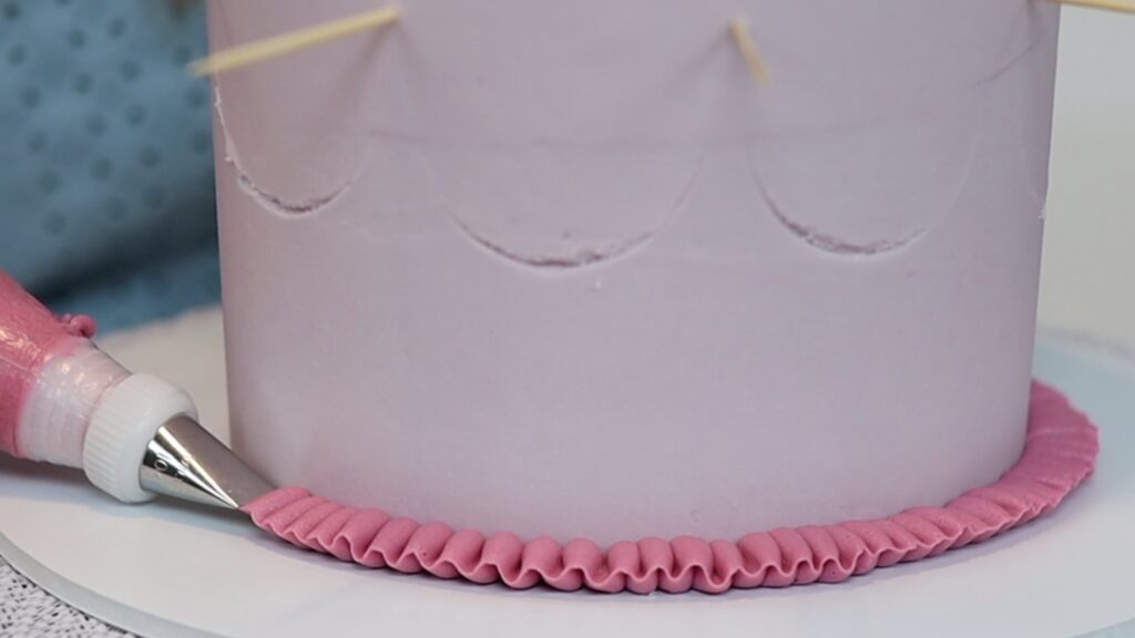 piping ribbons with a petal tip on a vintage cake