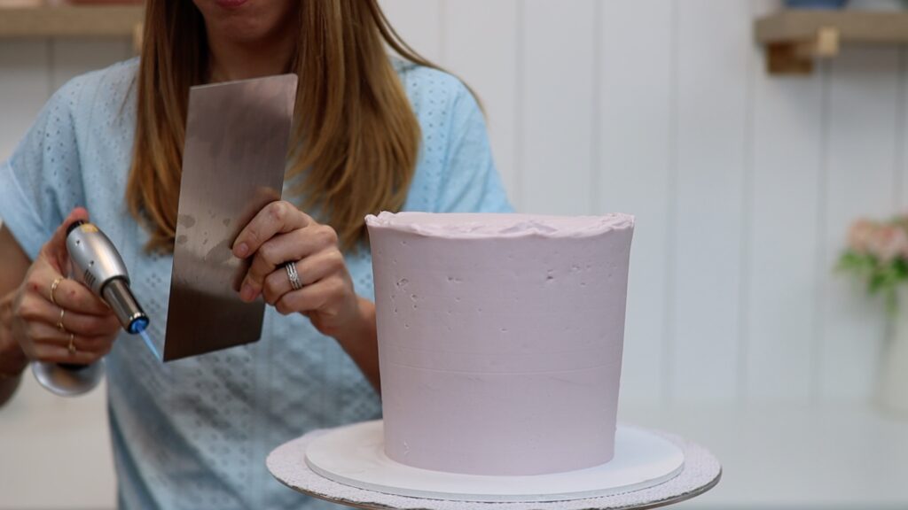 use a torch to heat a metal cake comb for smooth frosting on cakes