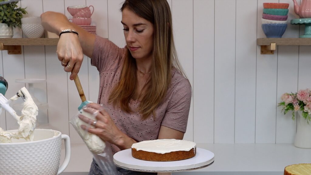 use a piping bag to pipe a buttercream dam around runny filling on layer cakes