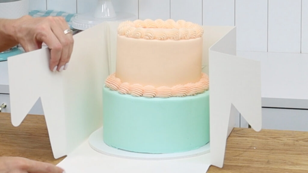 Tall tier cake sticking out above standard cake box