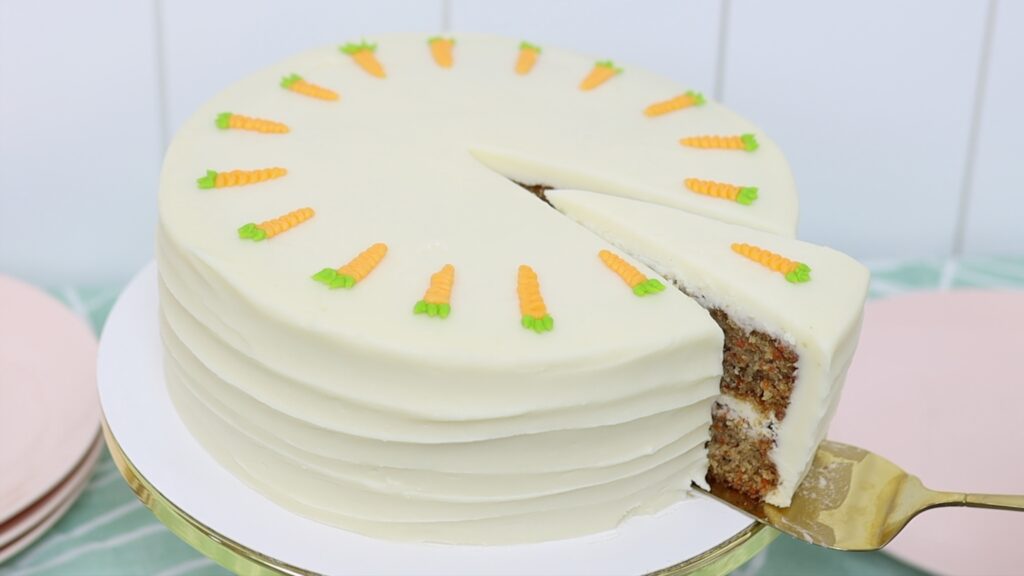slice of homemade carrot cake with cream cheese frosting and carrot decorations