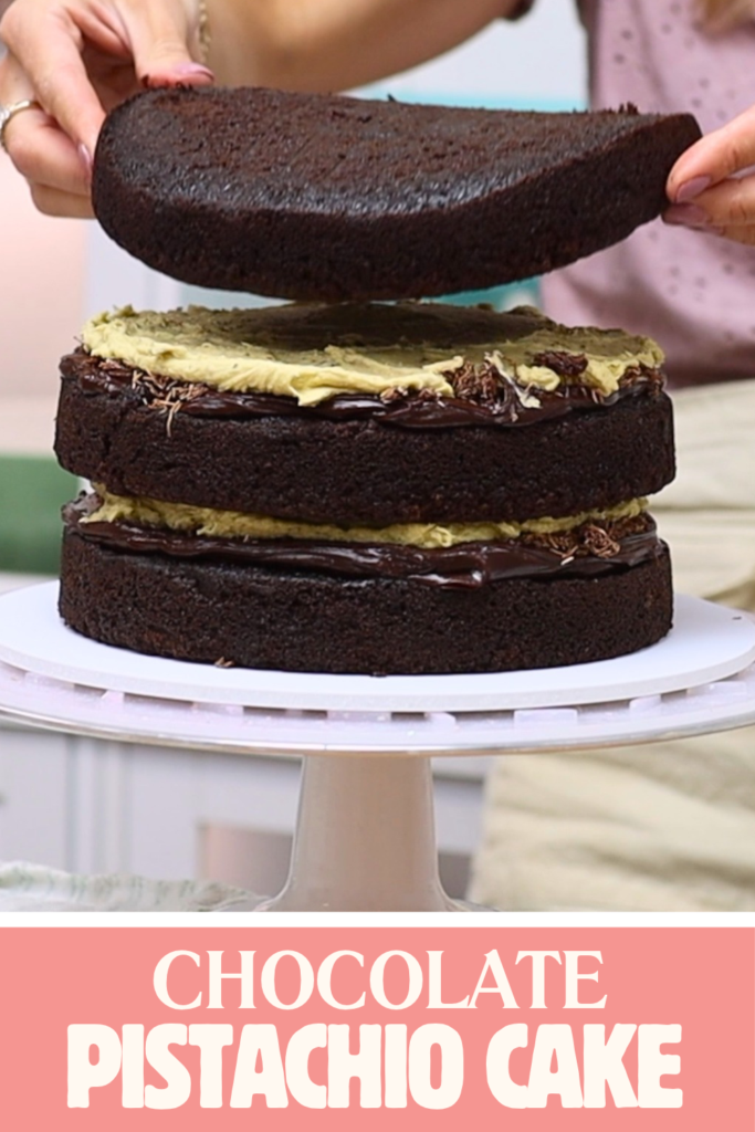 Stacking a chocolate layer onto a chocolate pistachio cake with pale green pistachio buttercream filling.