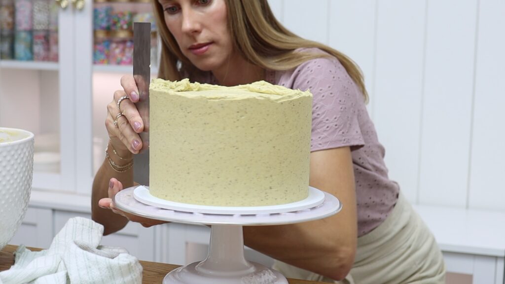 frosting a chocolate pistachio cake with pistachio buttercream frosting
